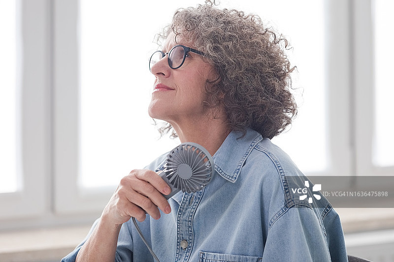 在办公室出现潮热的更年期妇女图片素材