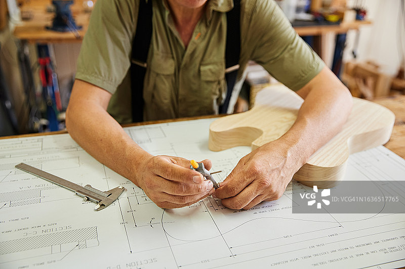 在工作室设计电吉他的制琴师图片素材