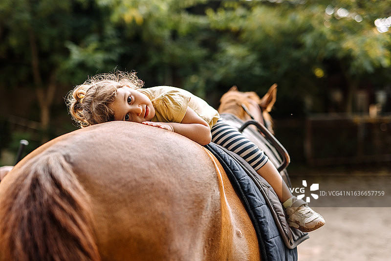 小女孩在农场骑马图片素材