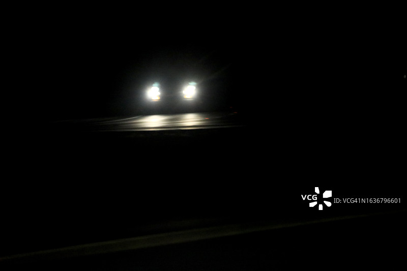 行驶中的车辆与明亮的车头灯图片素材