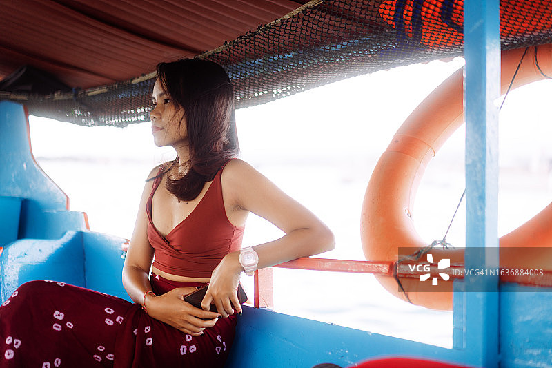 亚洲女人在苏拉威西岛塞拉亚岛附近乘木船浮潜图片素材