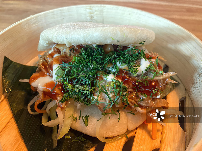 竹蒸笼盛放的手撕猪肉包图片素材