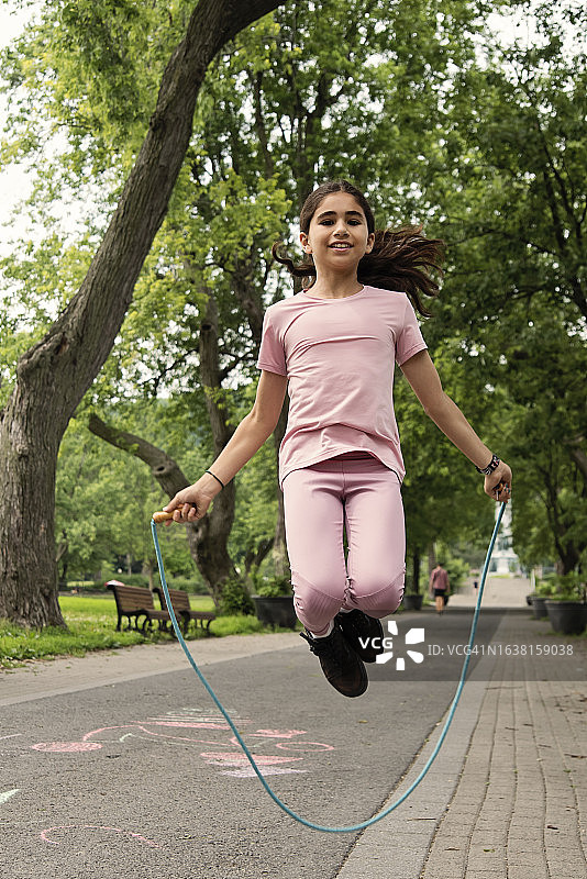 在公园跳绳的年轻活力中东女孩图片素材