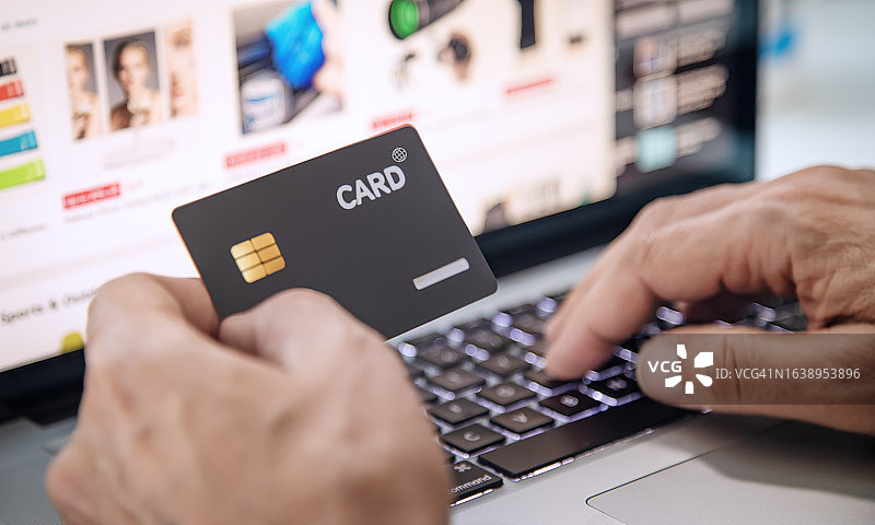 在线购物，特写镜头显示一个人用信用卡进行在线购物图片素材