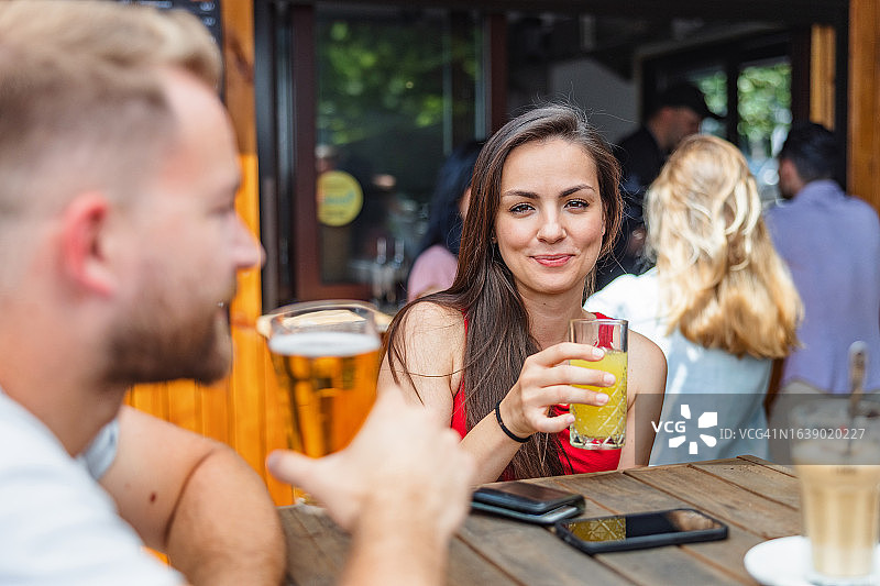 年轻白人女性在户外微笑饮用新鲜饮品图片素材