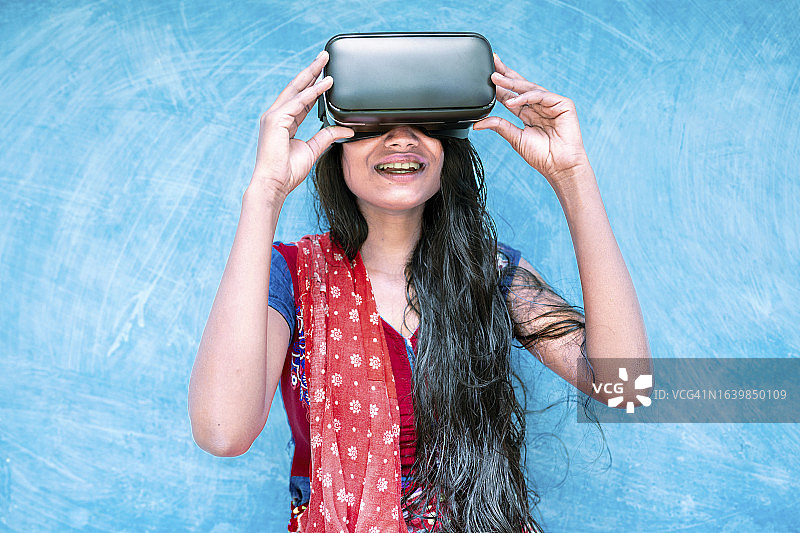 来自印度奥里萨邦Bhomia部落的美丽女人第一次体验虚拟现实眼镜，感到惊讶图片素材