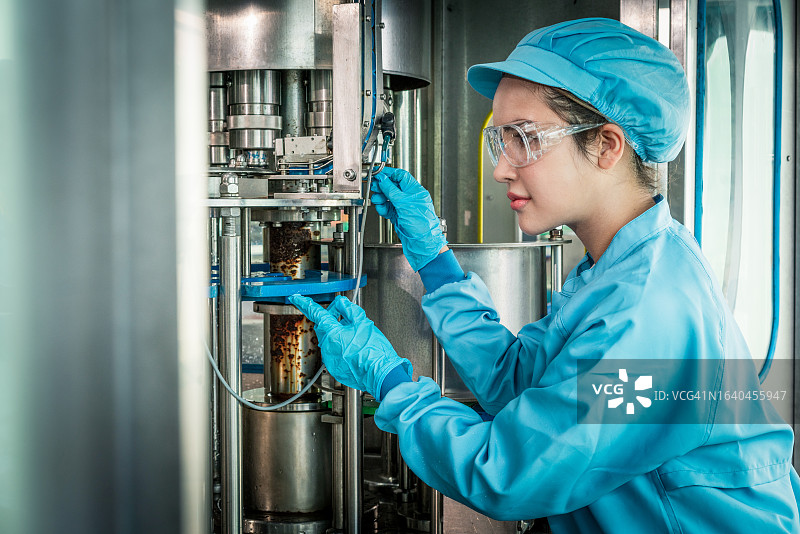 女科学家在工业工厂检查和监控机器系统的控制面板，记录控制面板数据并测量水位压力图片素材