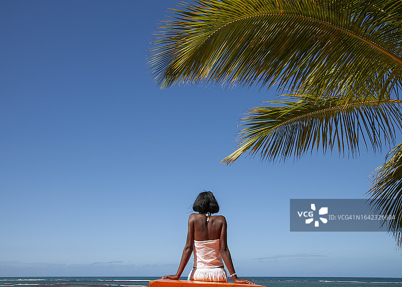 年轻女人坐在桌旁观看大海图片素材