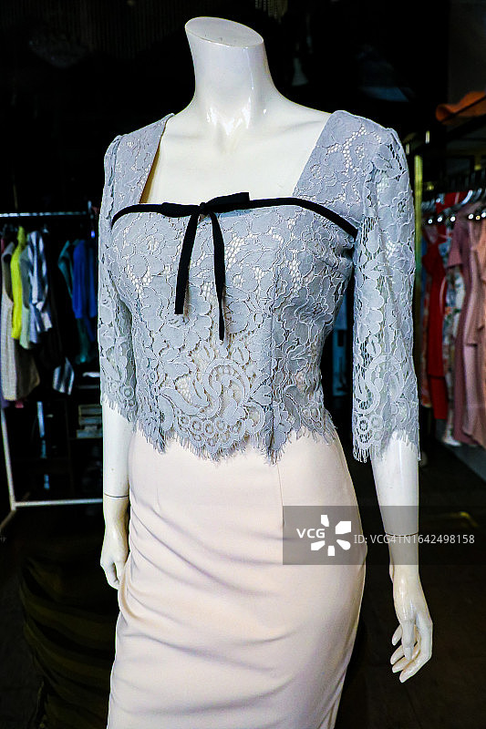 在倒闭的服装店橱窗里穿着休闲服装的女性人体模特图片素材