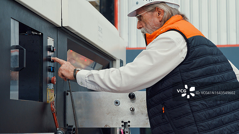 男性工业工程师在制造工厂检查机器设备，在制造工厂或生产工厂工作图片素材