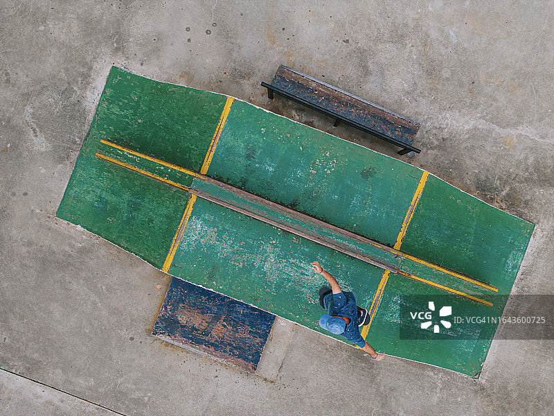 在滑板公园练习滑板的年轻男子的无人机视角俯视图图片素材