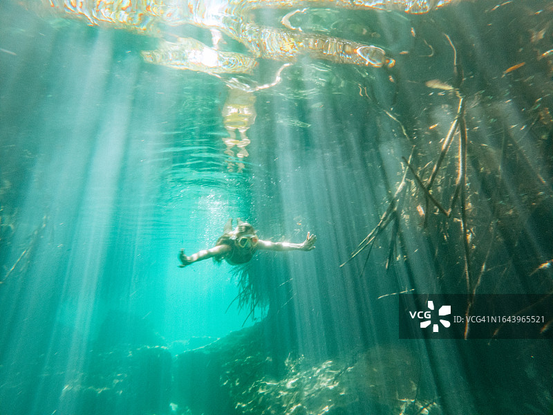 女人在热带石灰岩坑潜水，水下拍摄图片素材