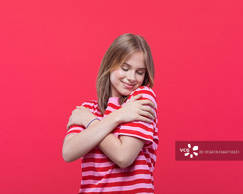 友善的青少年女孩拥抱自己肖像图片素材