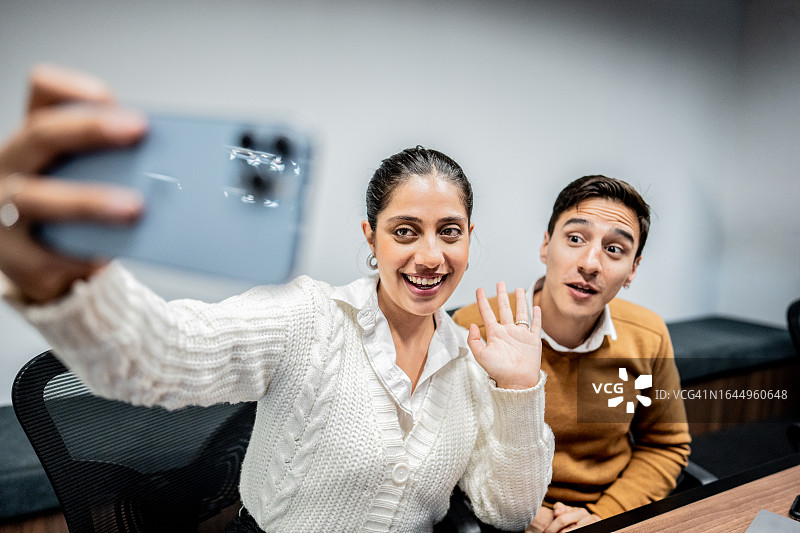 办公室同事用手机进行视频通话图片素材