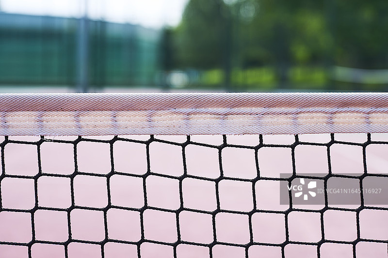 网球网的特写，背景是球场散焦镜头图片素材