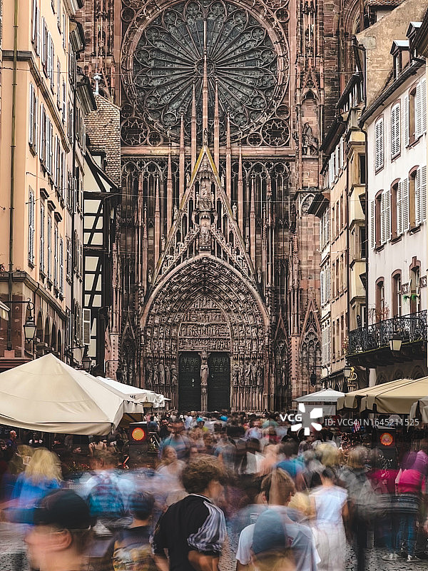 斯特拉斯堡圣母院背景下人群行走的长曝光摄影图片素材