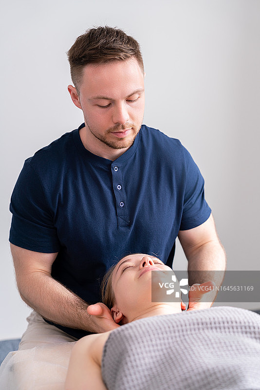医生为安静的女病人进行颈部和头部按摩图片素材