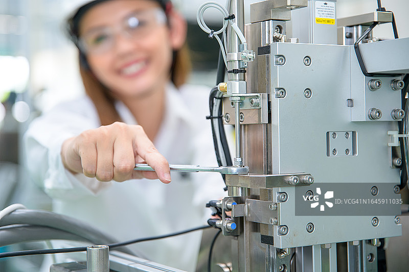 女工程师在工厂检查数控机床图片素材
