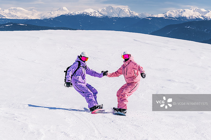 两位年轻女子在阳光明媚的日子里滑雪图片素材
