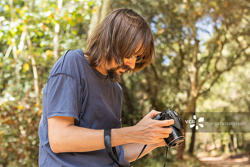 手持相机休息的男人图片素材