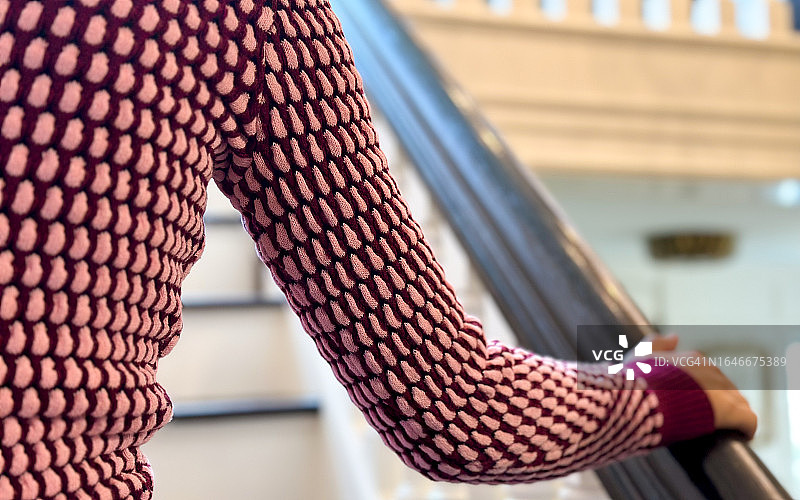 多种族年轻女性扶着扶手爬楼梯图片素材