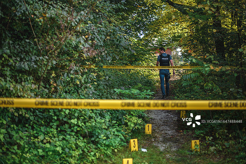 运动型侦探离开用警戒带标记的犯罪现场图片素材