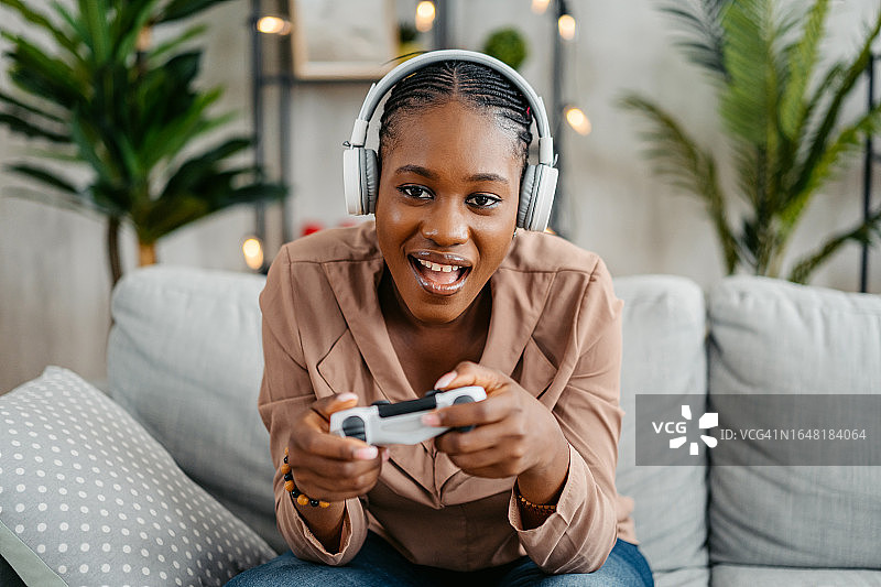 年轻女子在家玩电子游戏图片素材