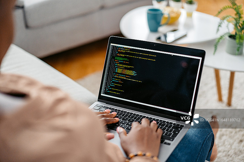 年轻女子在家用笔记本电脑编程图片素材