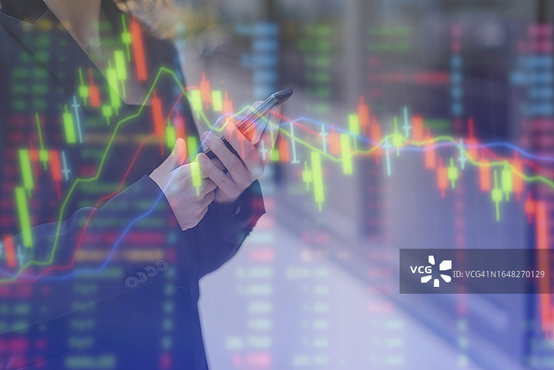 女人用智能手机投资股票市场图片素材