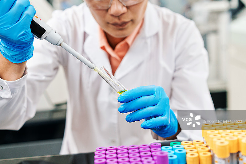 女医务人员在实验室用移液管填充化学物质图片素材
