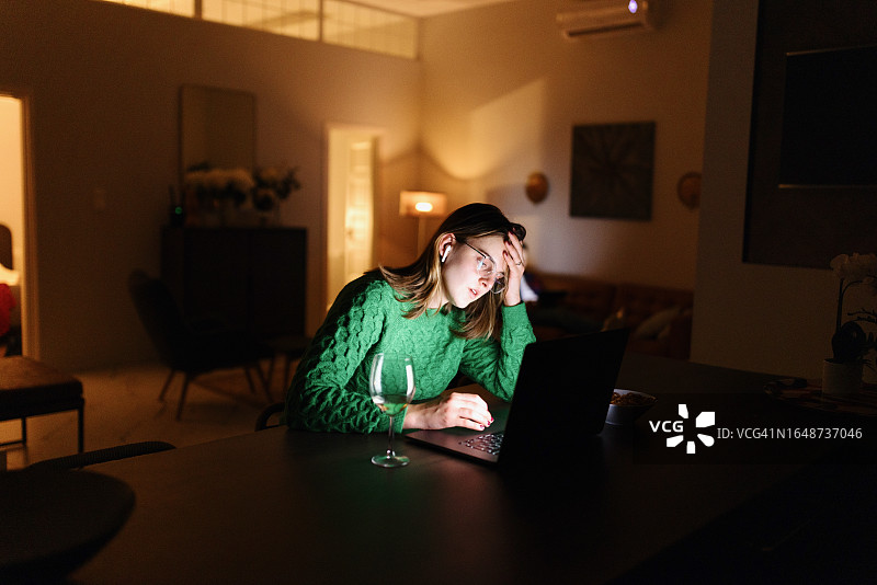疲惫的女人在晚上完成她的家庭工作图片素材
