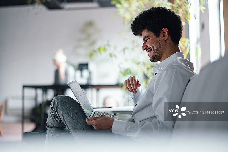 快乐的英俊商人使用电脑工作图片素材