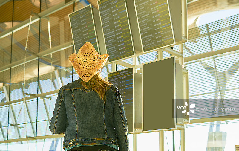 在威尼斯，穿着休闲的成熟女人戴着帽子看终点站的后视图图片素材