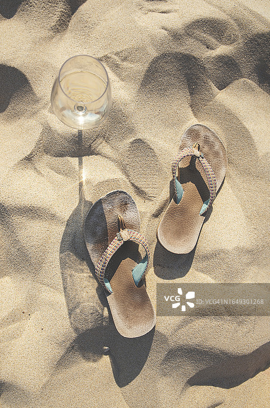 沙滩上的酒杯和人字拖图片素材