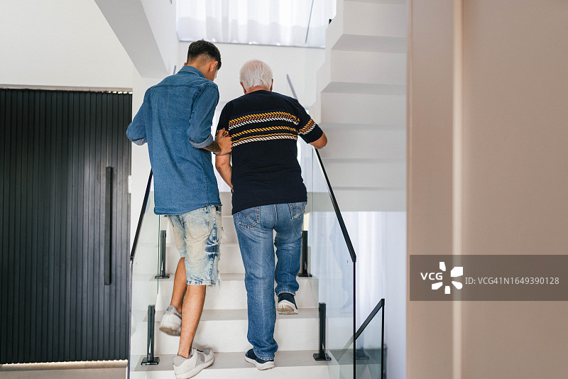 年轻男人搀扶爷爷上楼梯图片素材