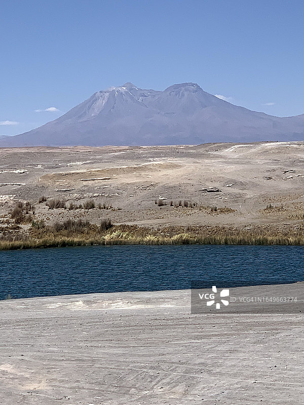 南美洲活火山背景下的沙漠景观和湖泊，智利北部安托法加斯塔地区的盐滩和高原上的层状火山，2022年11月图片素材