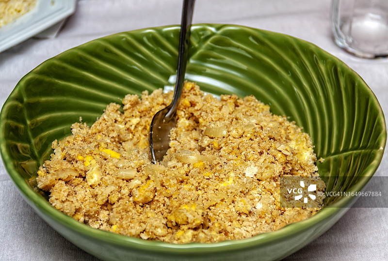 从上方看，一碗绿色的巴西木薯粉配鸡蛋和洋葱，是巴西黑豆饭的配菜图片素材