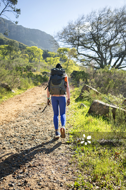 阳光明媚的早晨，年轻女子在铁轨上徒步旅行图片素材