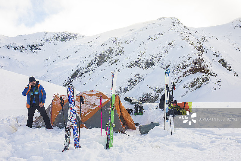 冒险男子用卫星电话呼叫直升机图片素材