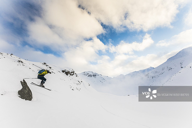 偏远滑雪者在小岩石上跳跃图片素材