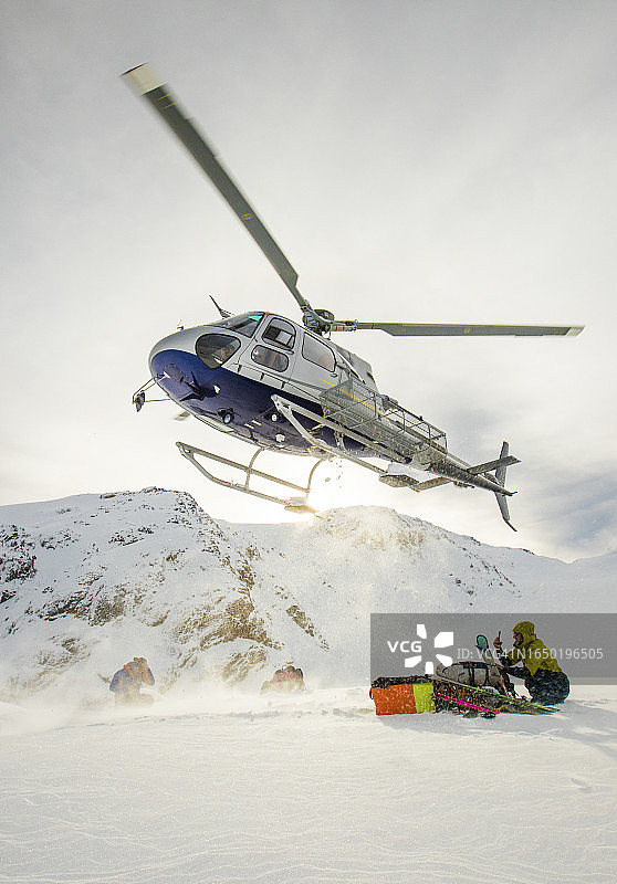 直升机降落在海岸山脉接滑雪者图片素材