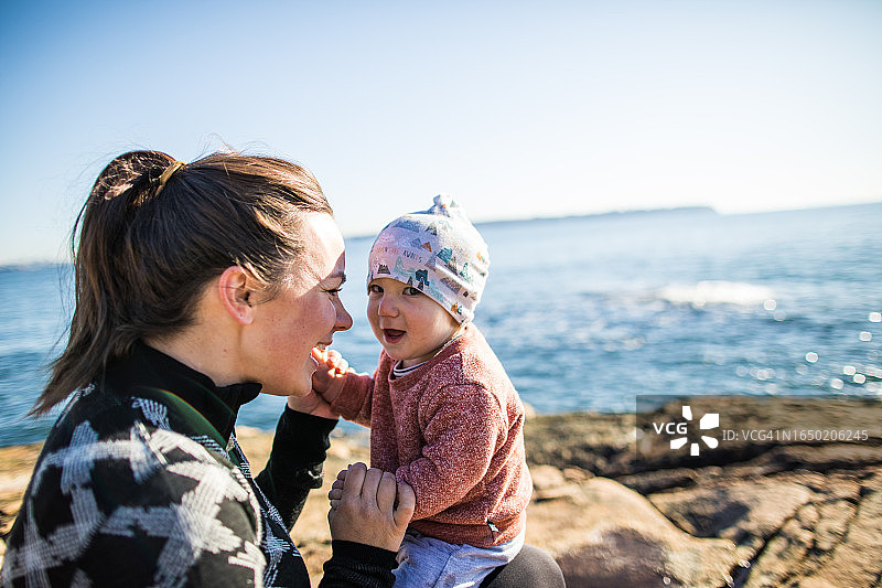 母亲充满爱意地抱着她的幼儿并互动图片素材