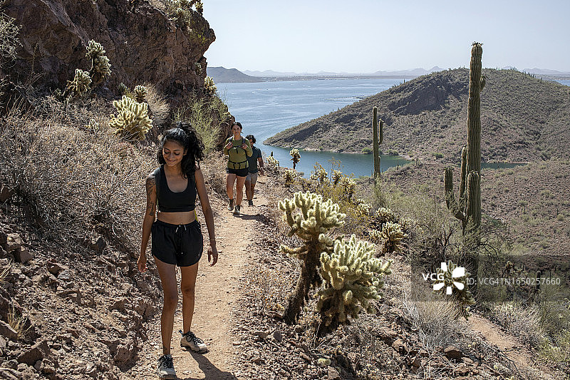 在山间小道上健行，背景是湖泊图片素材