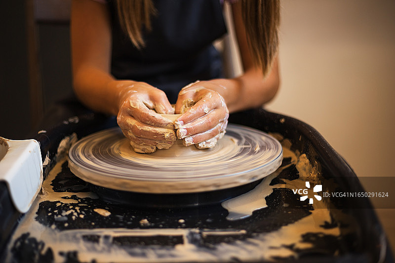 女孩在陶轮上制作碗图片素材