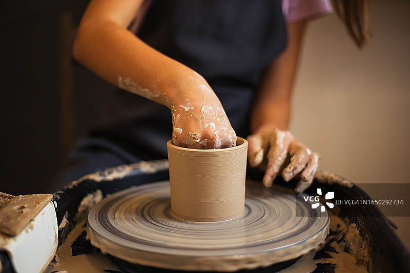 少女在陶轮上制作陶罐特写图片素材