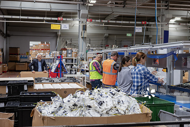 工人在工厂用螺丝刀在生产线上工作图片素材