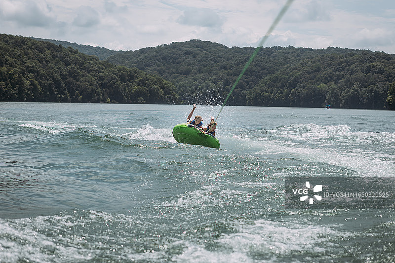 孩子们在轮胎上被快艇拖拽图片素材