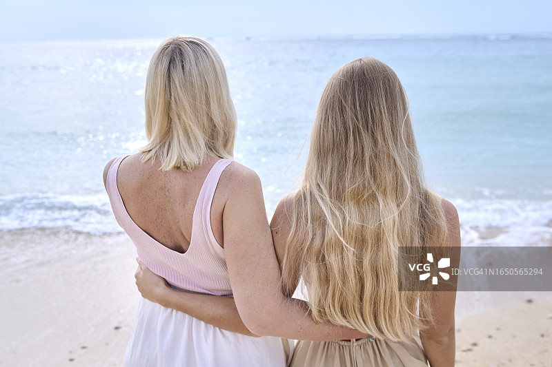 母亲和成年女儿站在海边的背影图片素材