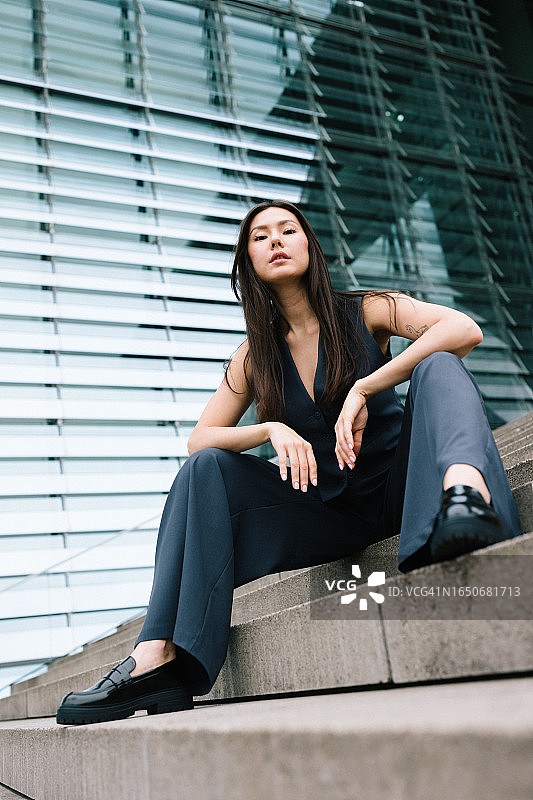 自信的年轻女性在现代建筑前的肖像图片素材