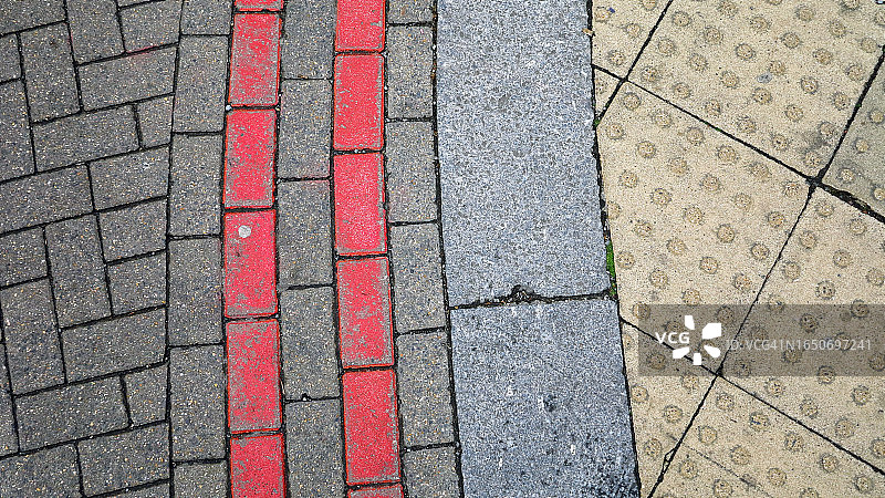 伦敦人行道特写：视障人士专用砖，红色路标的街道图片素材